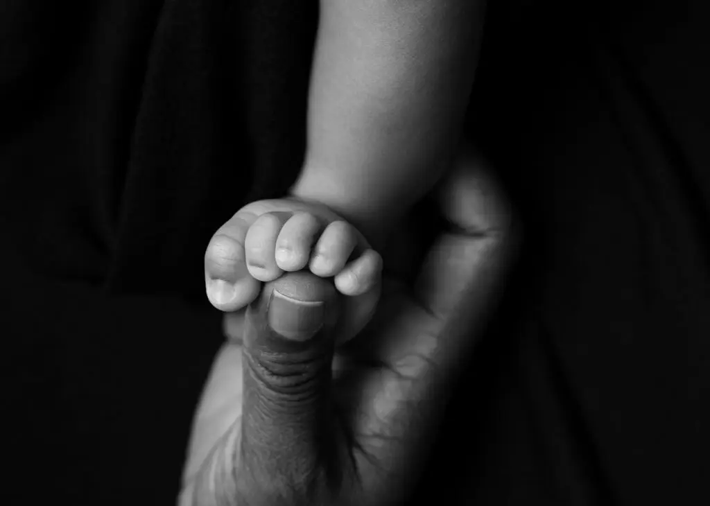 tiny feet detail close up newborn photo with moms hand